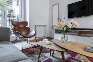 ein Wohnzimmer mit einem Sofa und einem Tisch in der Unterkunft Luxurious 2BR/2BA in Chueca in Madrid