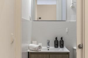 ein Badezimmer mit einem Waschbecken mit zwei Flaschen in der Unterkunft Luxurious 2BR/2BA in Chueca in Madrid