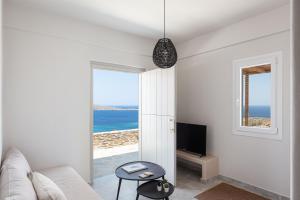 a white living room with a view of the ocean at Kythea Suites Kythnos in Kithnos