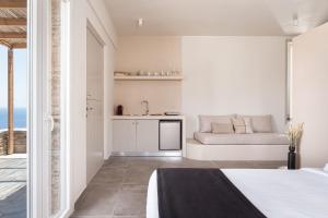 biały pokój z łóżkiem i kanapą w obiekcie Kythea Suites Kythnos w mieście Kitnos