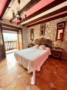 1 dormitorio con cama y pared de piedra en Apartamentos Nel I, en Santillana del Mar