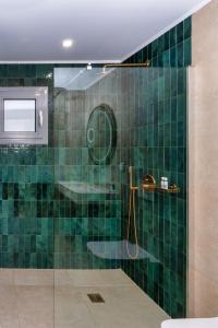 a green tiled bathroom with a shower and a sink at Selene Luxury Rooms in Armenistis +64 photos