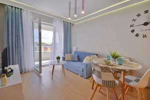 een woonkamer met een tafel en een blauwe bank bij Apartamenty Bryza - Sun Towers in Świnoujście