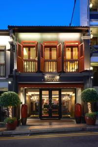 a store front of a building with windows and plants at The Scarlet Singapore in Singapore