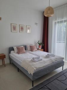 Un dormitorio con una cama grande con almohadas. en Baltivia Haus en Gdynia