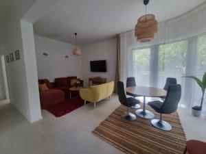 een woonkamer met een tafel, stoelen en een bank bij Baltivia Haus I in Gdynia
