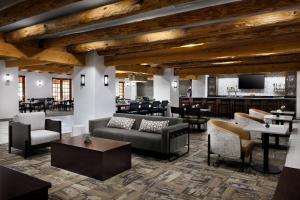 a lobby with couches and tables and a bar at Courtyard by Marriott Albuquerque in Albuquerque