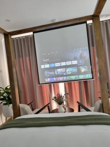 a projection screen in a room with chairs at Ashiyana Escapes in Mount Tamborine