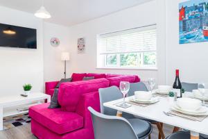 a living room with a pink couch and a table at Free Parking Big Garden Good Location in Swindon