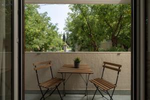 een tafel en 2 stoelen op een balkon met een tafel bij Charming Stay in Kolonaki in Athene