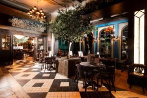 a restaurant with tables and chairs and a tree in the middle at The Harrogate Inn - The Inn Collection Group in Harrogate