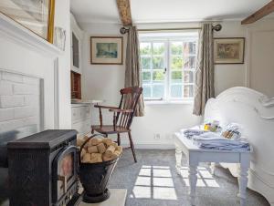 a living room with a fireplace and a chair at Mabel Cottage, Wickham in Wickham