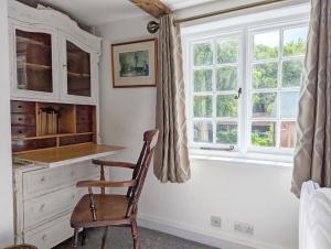 a chair in a kitchen with a window at Mabel Cottage, Wickham in Wickham