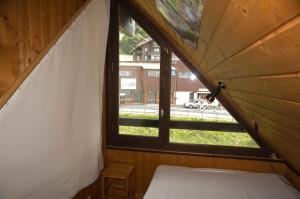 Cette chambre offre une vue sur une fenêtre et comprend un lit. dans l'établissement Duplex Le Yéti 16 Station Thollon les Mémises, à Thollon-les-Mémises