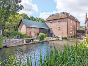 an old brick building next to a river at Mabel Cottage, Wickham in Wickham