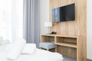 um quarto com uma secretária e uma televisão na parede em VacationClub - Aparthotel Czarna Góra 309 em Sienna