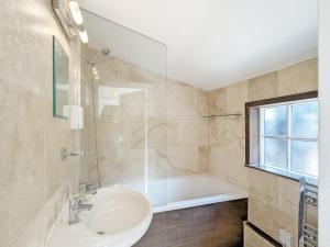 a bathroom with a sink and a bath tub at Mabel Cottage, Wickham in Wickham