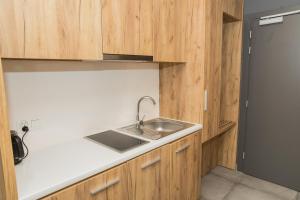 uma cozinha com um lavatório e armários de madeira em VacationClub - Aparthotel Czarna Góra 309 em Sienna