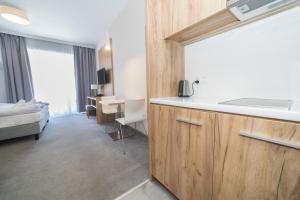 a hotel room with a kitchen and a bedroom at VacationClub - Aparthotel Czarna Góra 309 in Sienna