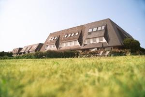 a building on top of a hill with a field at Boutique Suites Sylt in Kampen am Roten Kliff Re-Opening Mai 2023 in Kampen