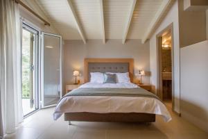 1 dormitorio con cama y ventana grande en Villa Stefanos, en Parga