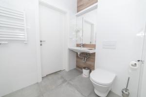 Baño blanco con aseo y lavamanos en VacationClub - Aparthotel Czarna Góra 221 en Sienna