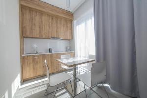 cocina con mesa, sillas y fregadero en VacationClub - Aparthotel Czarna Góra 221, en Sienna