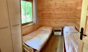 um pequeno quarto com 2 camas e uma janela em Ośrodek Wypoczynkowy Jeziornik em Borzechowo