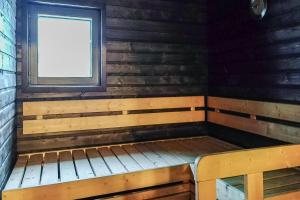 a sauna with a bench and a window at Holiday Cabin Ahjotar in Suomutunturi