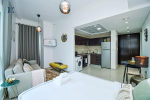 uma cozinha e sala de estar com um sofá e uma mesa em Newly Furnished Studio with Marina View - PAU em Dubai