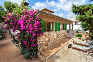 a house with flowers on the side of it at Can Picarola in Santanyi