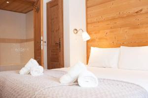 a bedroom with towels on a white bed at Powder Ridge - 6 bedroom chalet with hot tub in Tignes