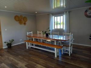 una sala da pranzo con tavolo e sedie in legno di L'Etreinte des Cimes a Cilaos
