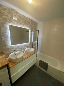 uma casa de banho com 2 lavatórios, um espelho e uma banheira em T3 sur les premières hauteurs à 10min de chambery em Saint-Alban
