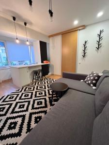 uma sala de estar com um sofá e uma mesa em Stilingi šaulio skulptūros apartamentai em Druskininkai