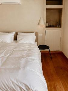 een groot wit bed in een kamer met een tafel bij Casa dos Mercados in Olhão
