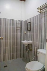 a bathroom with a toilet and a sink at CASA MIA INN in Dauis