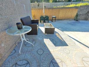 un patio con mesa y sillas en un suelo de baldosa en Hospedaje Athena en Pontevedra
