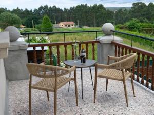 a patio with two chairs and a table on a balcony at Hotel El Rosal de Cudillero in Cudillero