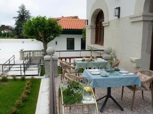 a patio with a table and chairs and a table at Hotel El Rosal de Cudillero in Cudillero