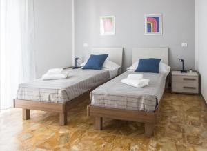 - une chambre avec 2 lits dotés d'oreillers bleus dans l'établissement Il Centrale, à La Spezia