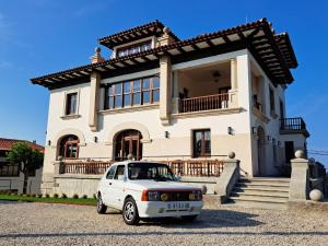 a white car parked in front of a house at Hotel El Rosal de Cudillero in Cudillero