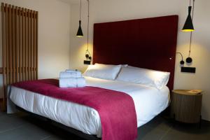 a bedroom with a large white bed with a red headboard at Hotel El Rosal de Cudillero in Cudillero