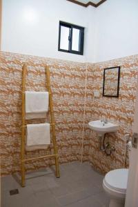een badkamer met een handdoekradder en een wastafel bij CASA MIA INN in Dauis