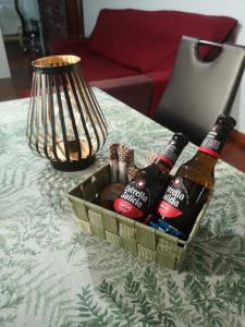 dos botellas de cerveza en una cesta sobre una mesa en Hospedaje Athena en Pontevedra