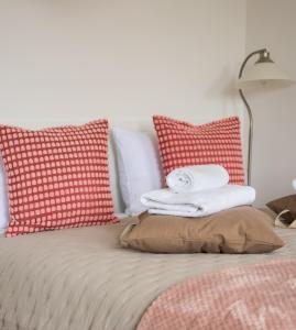 a bed with red and white pillows on it at Polna Centrum Studio in Warsaw