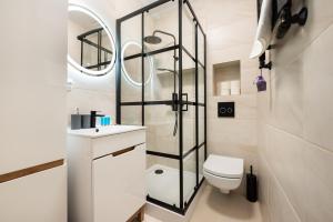 a bathroom with a toilet and a glass shower at Polna Centrum Studio in Warsaw