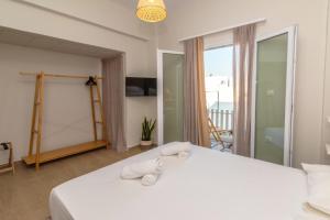 a bedroom with a large white bed with a balcony at Azure in Tinos in Tinos