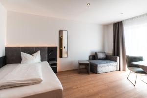 sypialnia z łóżkiem, krzesłem i stołem w obiekcie Landhotel Prielbauer w mieście Mondsee