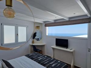 um quarto com uma cama e uma secretária com um computador em Amerisa Suites & Villa em Fira